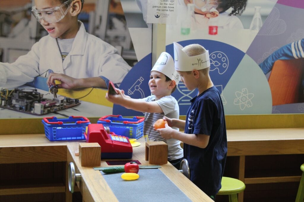 Two Kids in Midtown Market Playing With Fake Food in KidsPlace
